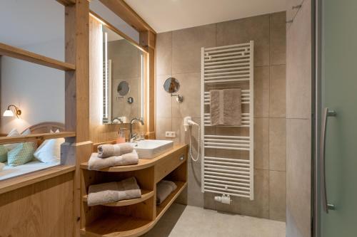 ein Bad mit einem Waschbecken und einer Dusche in der Unterkunft Gasthof Oberstegen in Söll