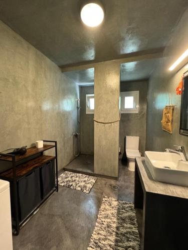 uma casa de banho com um lavatório e um WC em Family house em Keratea