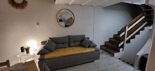 un salon avec un canapé et un miroir dans l'établissement Petit Boudha climatisé Mezzanine rénové parking 400m plage 50m commerces, au Grau-du-Roi