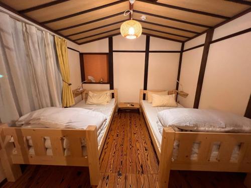a room with two twin beds in a room at Dormitory Omitsu in Nara