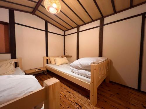 a room with two twin beds and a ceiling at Dormitory Omitsu in Nara