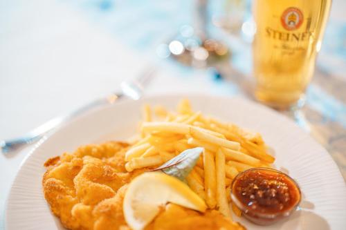a plate of food with fries and sauce and a drink at Hotel Plankl in Altötting