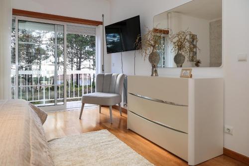 a bedroom with a bed and a desk with a chair at Moradia Chicharro in Nazaré
