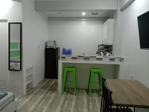 a kitchen with green bar stools and a counter at Enamorado Studios in Angeles