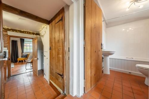a bathroom with a toilet and a sink and a tub at Teacup Cottage 2 in Syderstone