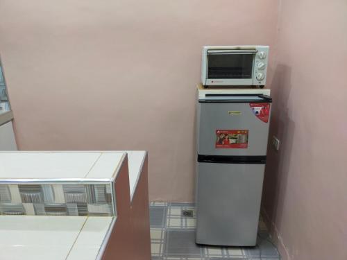 a microwave sitting on top of a refrigerator at Enamorado Studios in Angeles