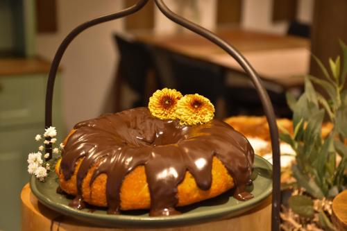 Ein Schokoladenkuchen mit Blumen darauf auf einem Teller in der Unterkunft Pousada Belluno in Gramado