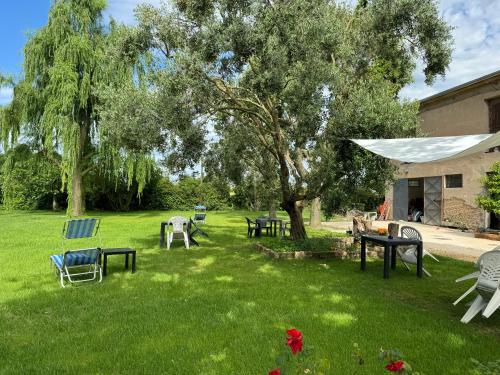 a group of tables and chairs in a yard with a tree at Affittacamere Ca' de Mazapedar in San Lorenzo