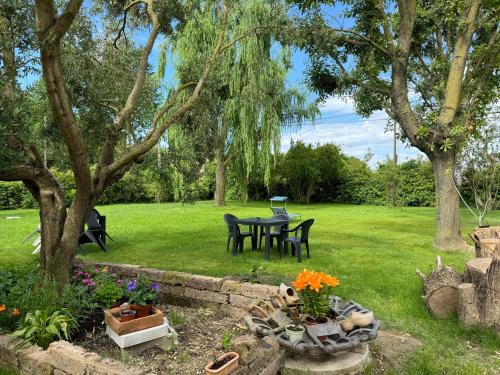 a garden with a table and chairs in the grass at Affittacamere Ca' de Mazapedar in San Lorenzo