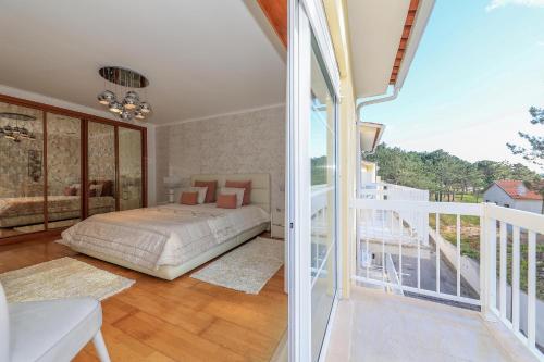 una camera da letto con un letto e un balcone di Moradia Chicharro a Nazaré