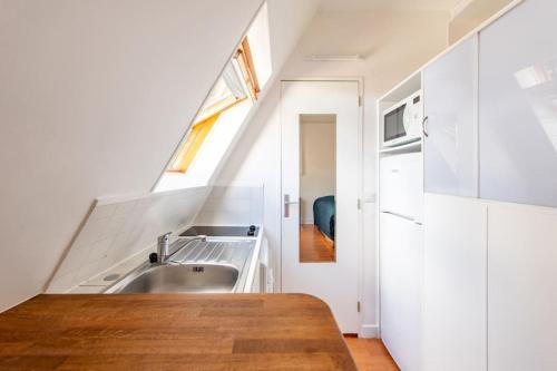 une petite cuisine avec un évier et une fenêtre dans l'établissement Paris Centre Studio Close to Major Attractions, à Paris
