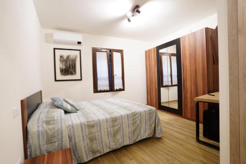 a bedroom with a bed and two windows at Cà Mandarein in Quattro Castella