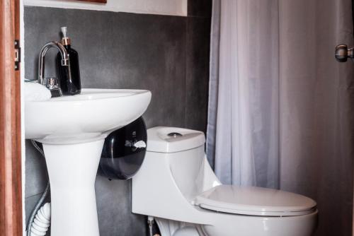 a bathroom with a white sink and a toilet at Che Zipolite Hostel & Beach Club in Zipolite