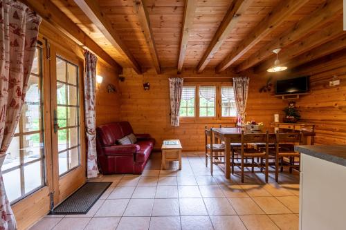 - un salon dans une cabane en rondins avec une table et des chaises dans l'établissement Chalet mitoyen 4 personnes, à Alex