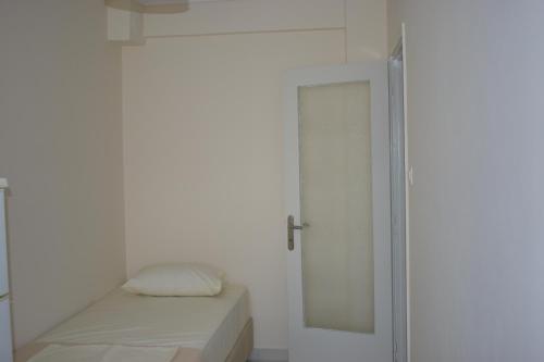 a white room with a bed and a mirror at By The Sea in Asprovalta