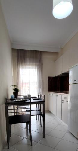 a kitchen with a table and a chair and a refrigerator at By The Sea in Asprovalta