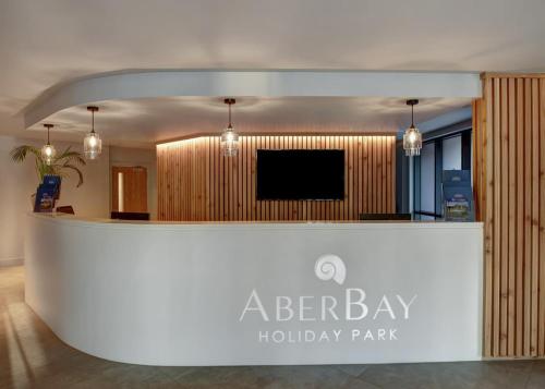 a lobby with a reception desk with a flat screen tv at Aber Bay Holiday Park in Aberystwyth