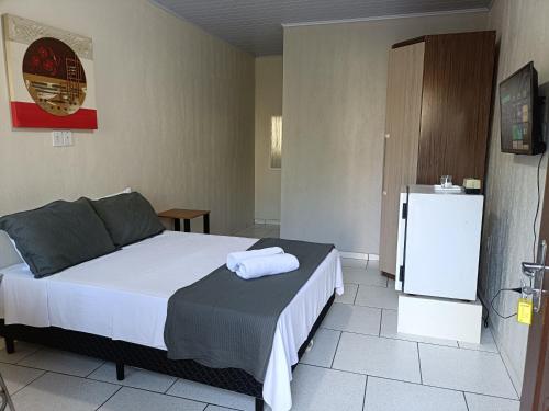 a bedroom with a bed and a refrigerator at Della Foz in Foz do Iguaçu