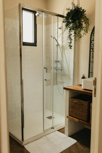 une douche avec une porte vitrée dans une salle de bain dans l'établissement L'Atelier de Roger, à Le Bourg-Dun