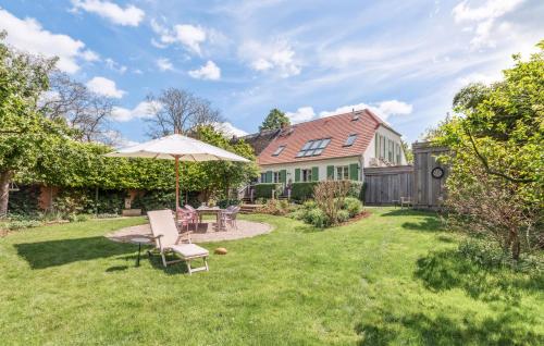 a patio with an umbrella and chairs in a yard at Awesome Home In Netzeband With Sauna in Netzeband