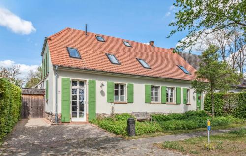 a white and green house with a red roof at Awesome Home In Netzeband With Sauna in Netzeband