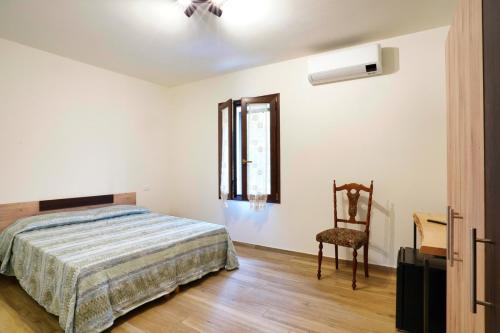 a bedroom with a bed and a chair at Cà Mandarein in Quattro Castella