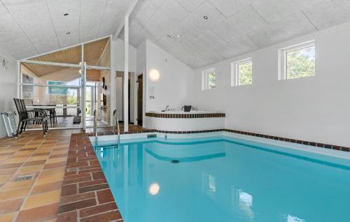 a large swimming pool in a room with a house at Cozy Home In Knebel With Sauna in Knebel
