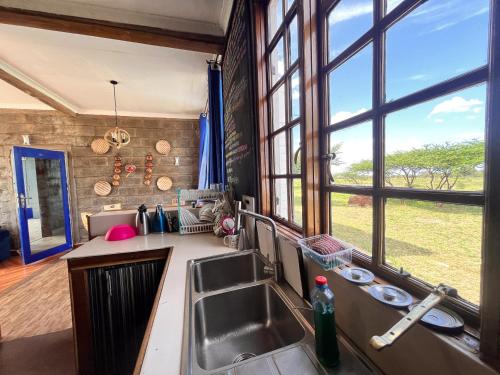 una cucina con lavandino e una grande finestra di Amboseli Glass house a Oloitokitok 