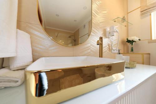 La salle de bains est pourvue d'un lavabo blanc et d'un miroir. dans l'établissement Moradia Chicharro, à Nazaré