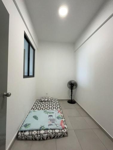 a white room with a bed in the middle of it at Lovely Green Forest in Sandakan