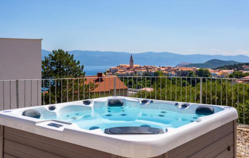 a hot tub on the balcony of a house at Pet Friendly Home In Vrbnik With Wifi in Vrbnik