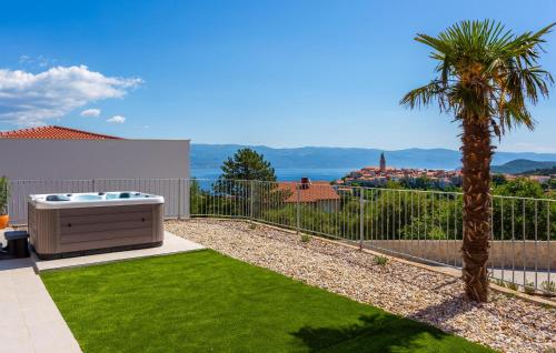 a backyard with a hot tub and a palm tree at Pet Friendly Home In Vrbnik With Wifi in Vrbnik