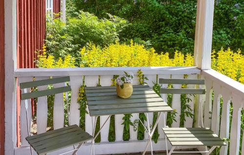 a table and two chairs on a porch with flowers at 4 Bedroom Lovely Home In Lammhult in Lammhult