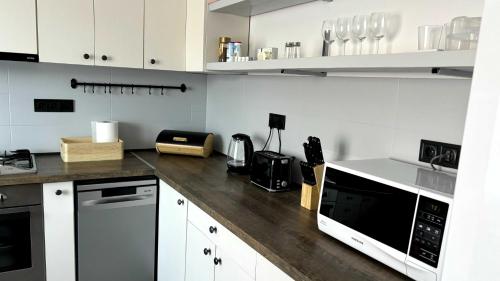 a kitchen with white cabinets and a wooden counter top at By the Center in Balatonalmádi