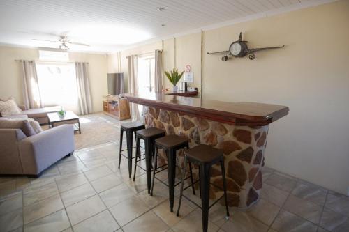 a living room with a bar with stools at The Bushveld Farmhouse in Mabalingwe Nature Reserve in Warmbaths
