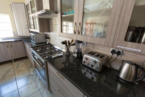 a kitchen with a stove and a counter top at The Bushveld Farmhouse in Mabalingwe Nature Reserve in Warmbaths