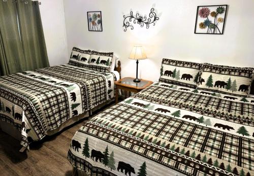 a bedroom with two beds and a table with a lamp at The Evening Shade River Lodge and Cabins in Chimney Rock