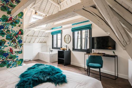 a bedroom with a bed and a desk and a tv at De Bij Middelbrug in Middelburg