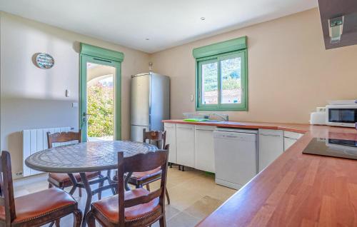 a kitchen with a table and chairs and a kitchen with a counter at Nice Home In Plan-D'aups-Sainte-Bau in Plan dʼAups