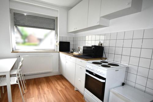 a white kitchen with a stove and a window at Blickfang Köln- Frechen 3 Zimmer 70qm in Frechen