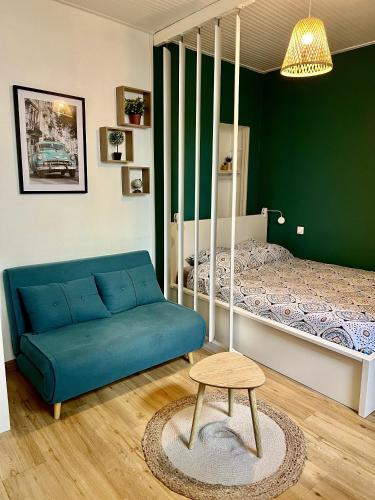 - un salon avec un canapé bleu et un lit dans l'établissement Studio Océan Remblai, à Les Sables-dʼOlonne