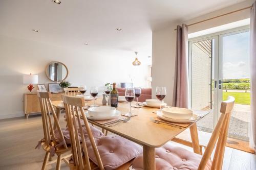 a dining room with a table and chairs and a window at Kingfishers Cove in Titchwell