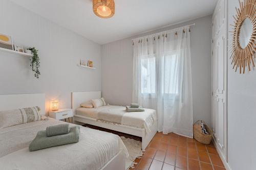 a bedroom with two beds and a window at 2BDR Ocean View & Large PRIVATE Terrace in Puerto de Santiago in Puerto de Santiago