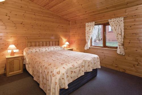 una camera con un letto in una baita di tronchi di Ogwen Bank Caravan And Lodge Park a Bethesda