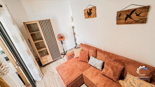 a living room with a brown couch in a room at Chalet Tikaz Sandjo in LʼEntre-Deux