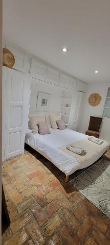 une chambre avec un grand lit blanc dans une pièce dans l'établissement Petite maison mitoyenne au cœur de Saint tropez, à Saint-Tropez