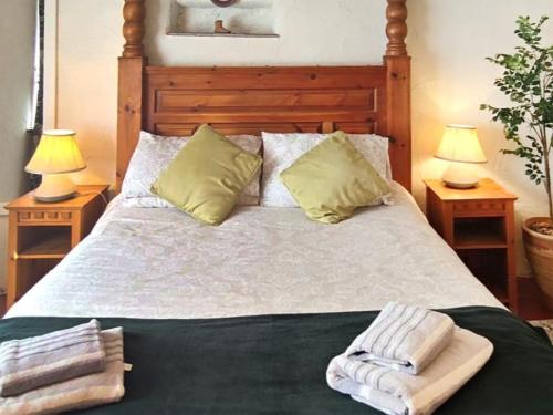 ein Schlafzimmer mit einem Bett mit zwei Lampen und zwei Handtüchern in der Unterkunft Laity in Polperro