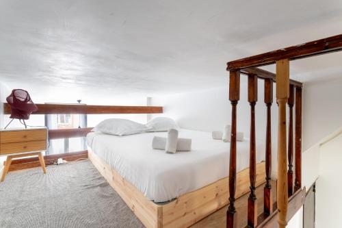 une chambre avec un lit en bois avec des draps blancs dans l'établissement Bel Appartement avec extérieur proche du métro - Lille, à Lille