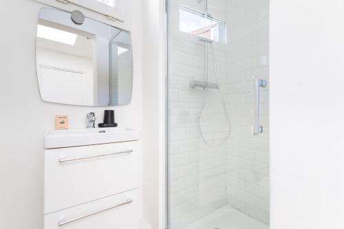 une salle de bain blanche avec une douche et un lavabo dans l'établissement Bel Appartement avec extérieur proche du métro - Lille, à Lille