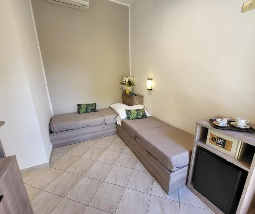 a small room with two beds and a tv at Hotel Villa Fulgida in Cattolica